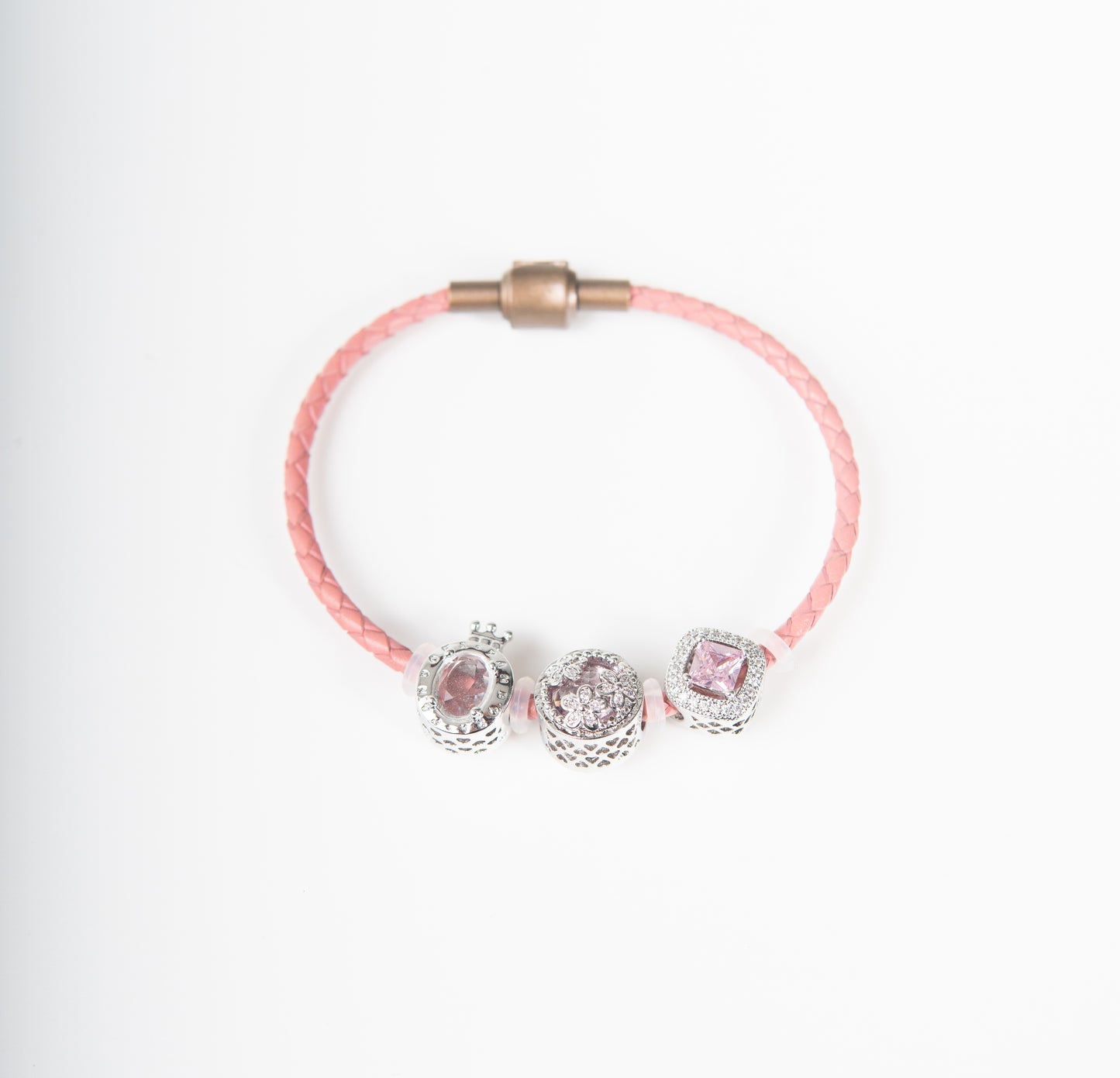 Brazalete de cuerina tejida rosada con dijes plateados