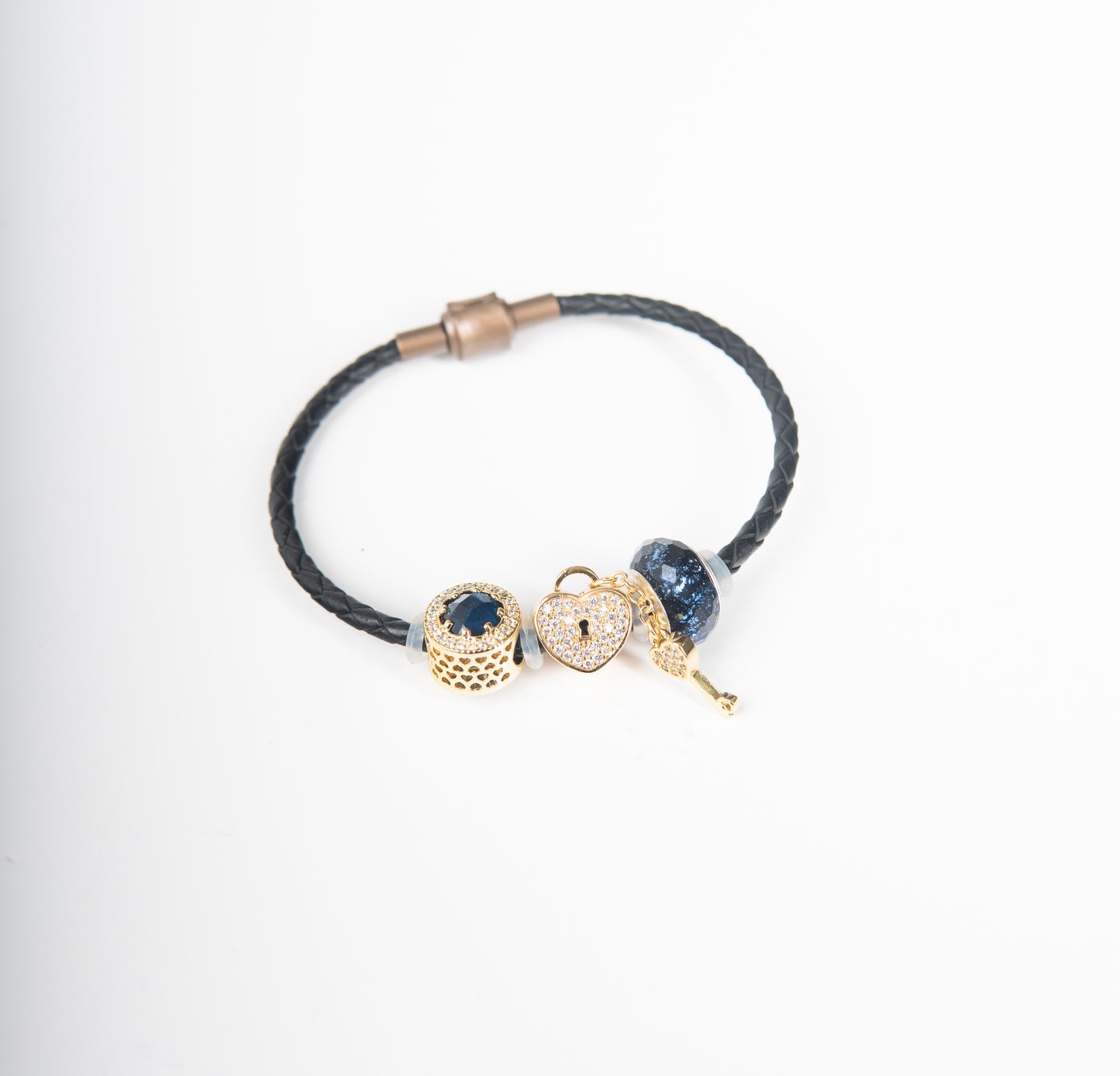 Brazalete de cuerina tejida con dijes dorados